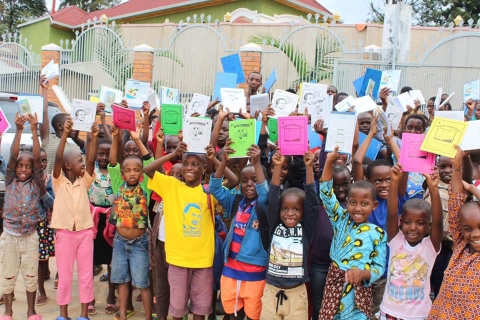 Irembo children holding up their new exercise books