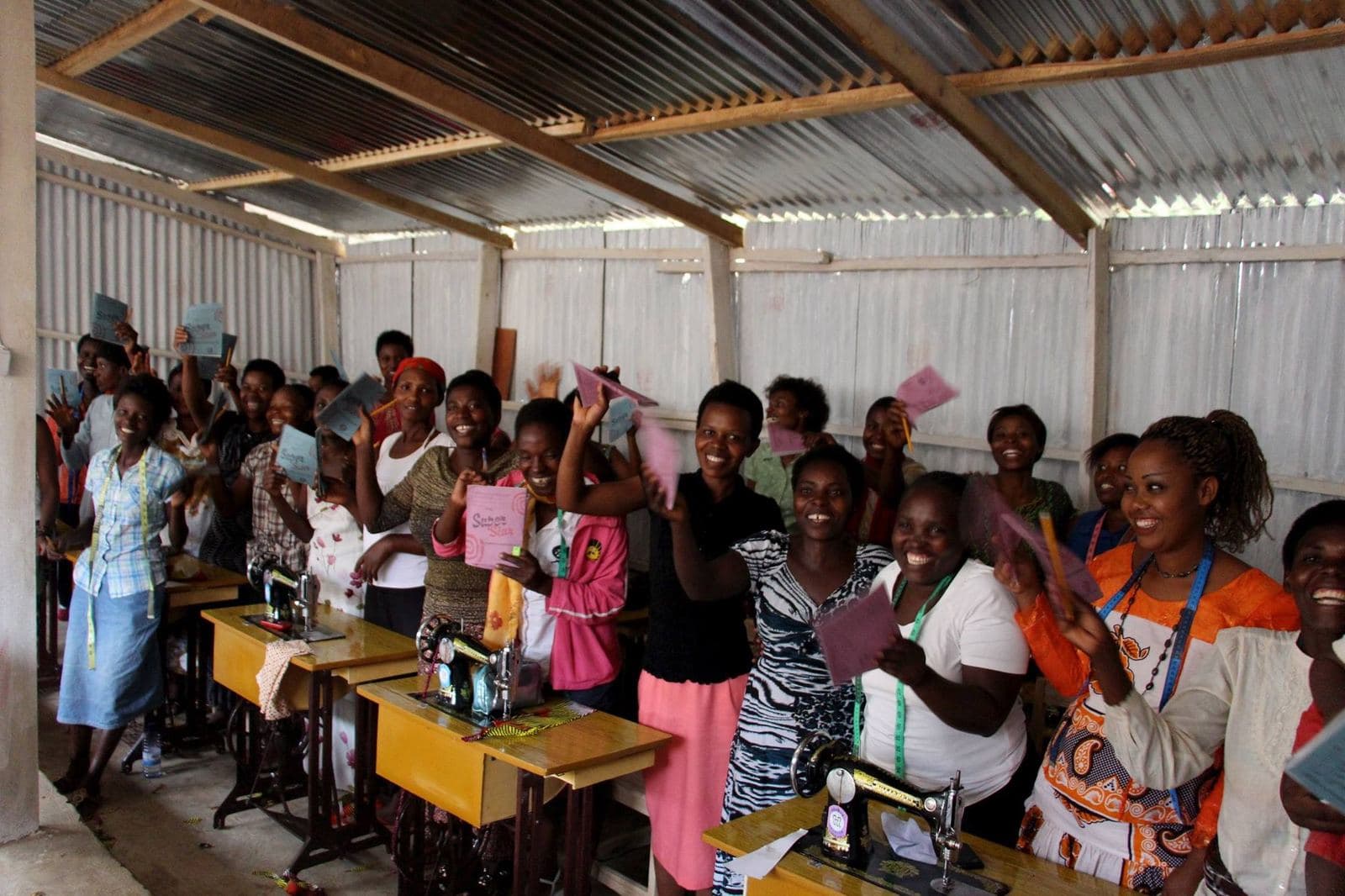 Mama Rwanda trainees celebrating at their sewing machines