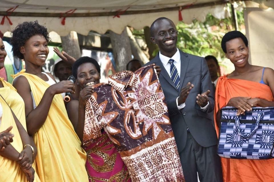 Graduates proudly showing a shirt and a bag they made