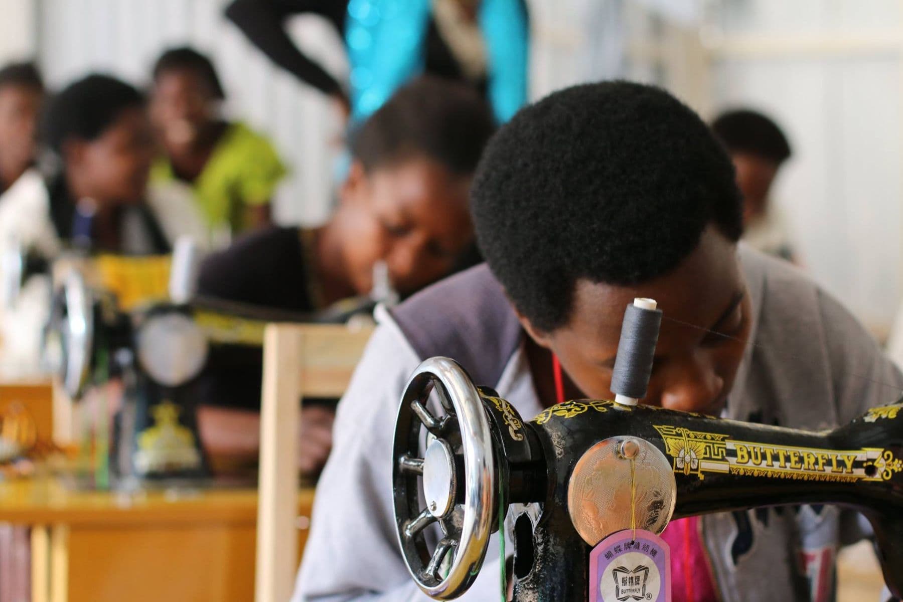 A trainee concentrating at her sewing machine