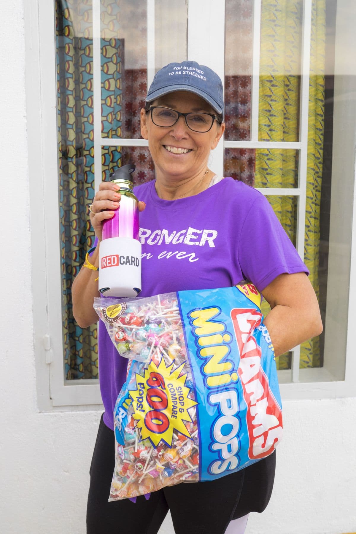 A smiling visitor holding a big bag of lollipops for the children