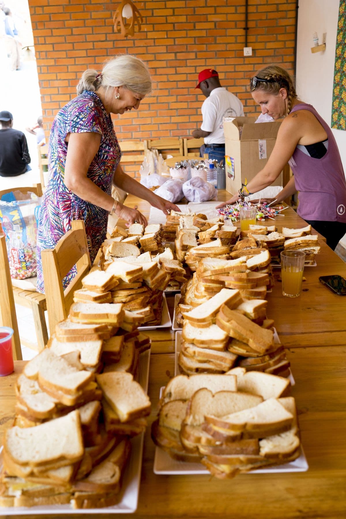 Volunteers preparing trays of sandwiches for the children