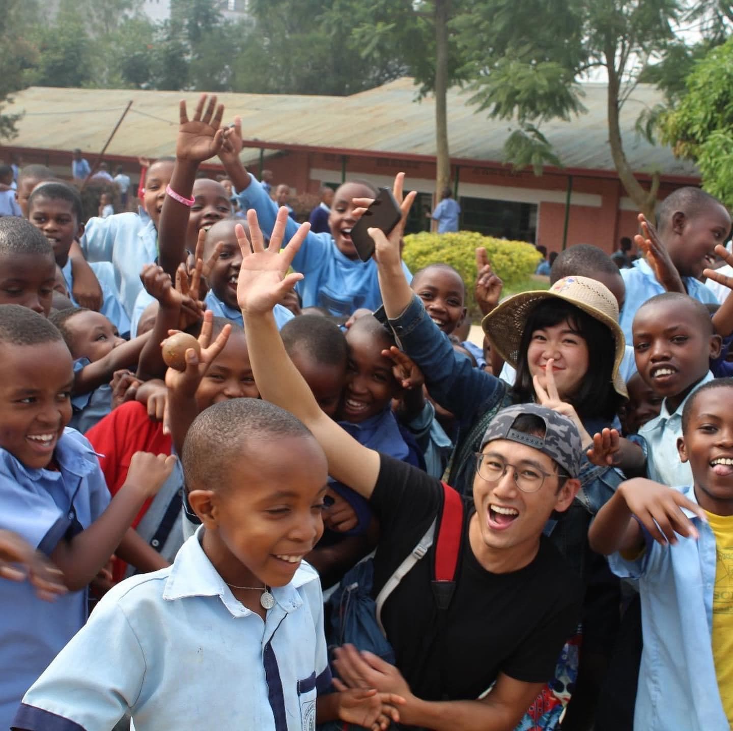 Schoolchildren in uniform celebrating with visitors
