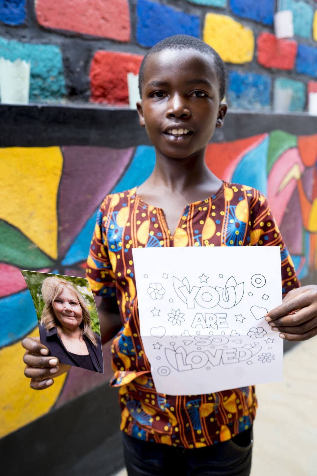 A boy holding his sponsor’s photo and a card