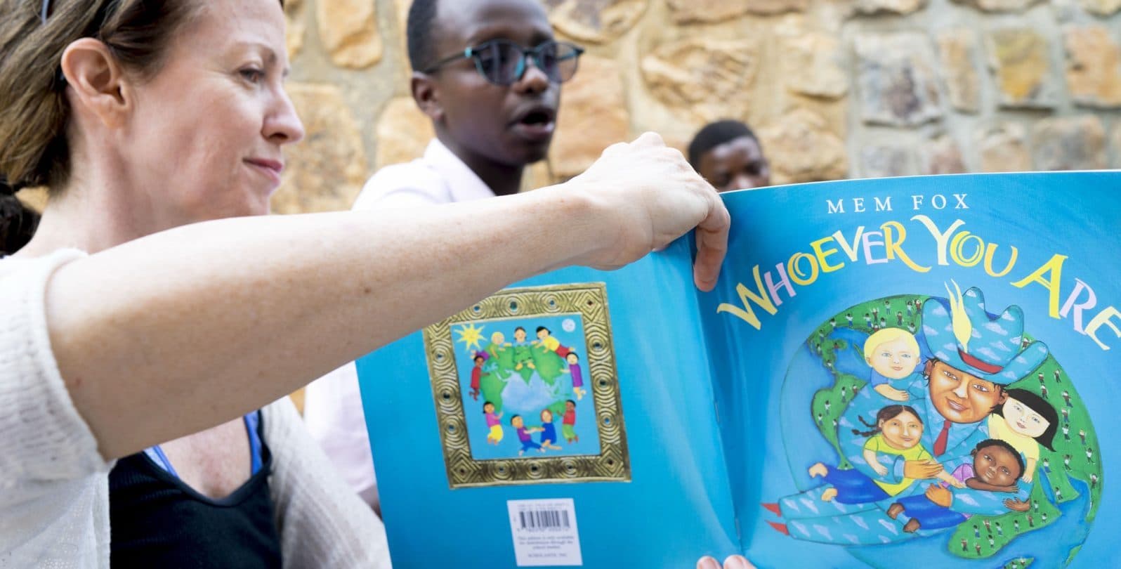 A visitor holding up a picture book during story time
