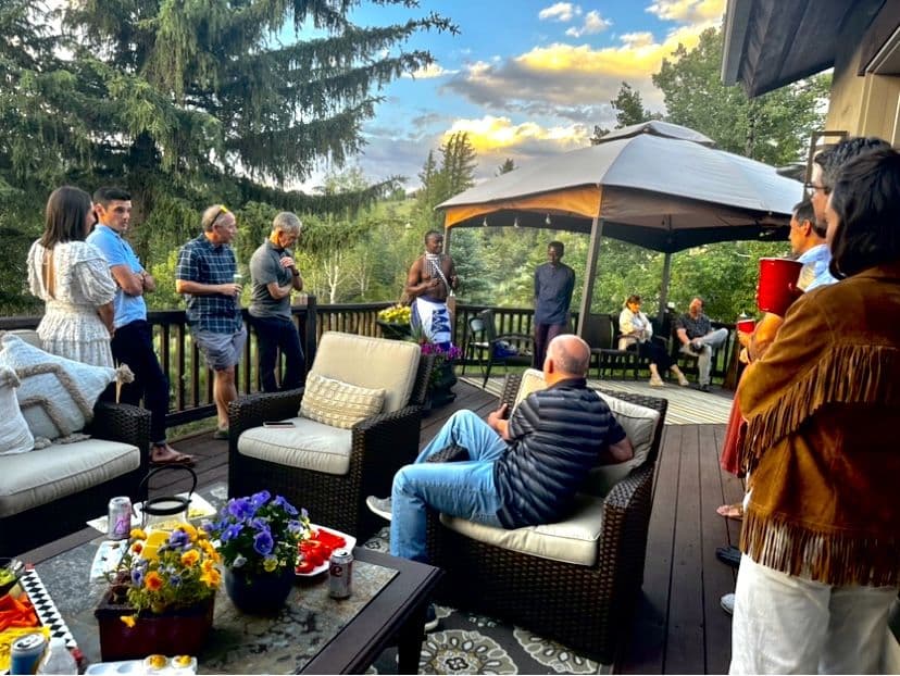 Supporters gathered on a deck at sunset for an Irembo US evening with a Rwandan dancer